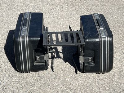 Universal motorcycle hard luggage saddlebags with mounting rack.