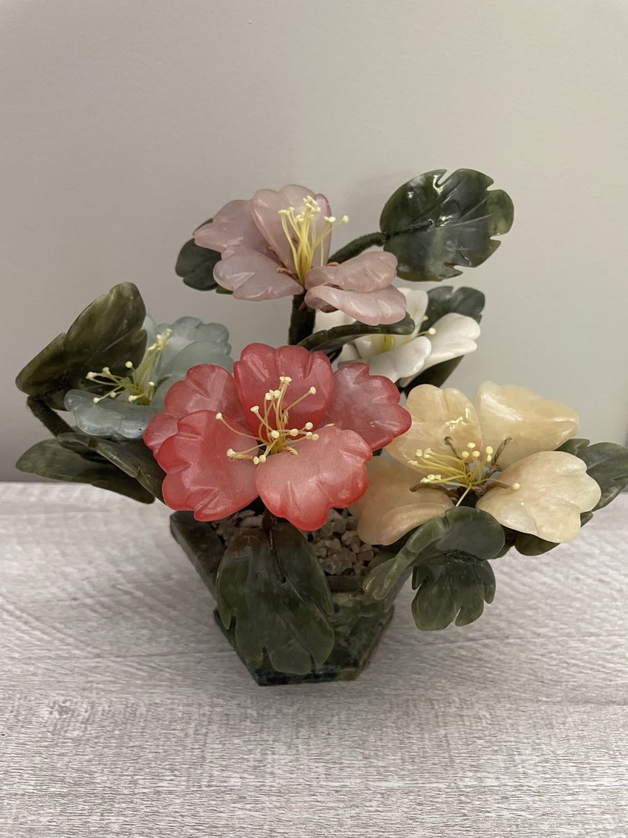 Vintage chinese jade peony plant features multi-colored blossoms dark green leaves in a pebbled pot