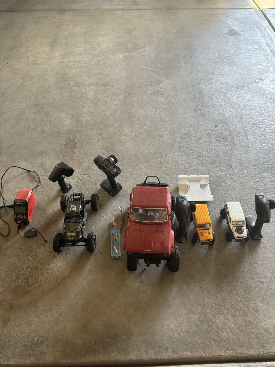 RC Crawler Lot with Multiple Vehicles, Remotes, and Charger