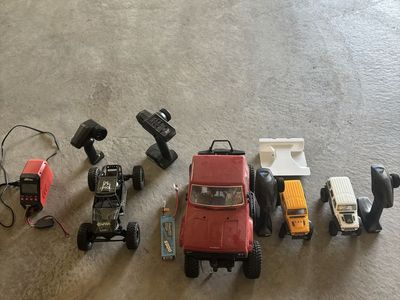 RC Crawler Lot with Multiple Vehicles, Remotes, and Charger