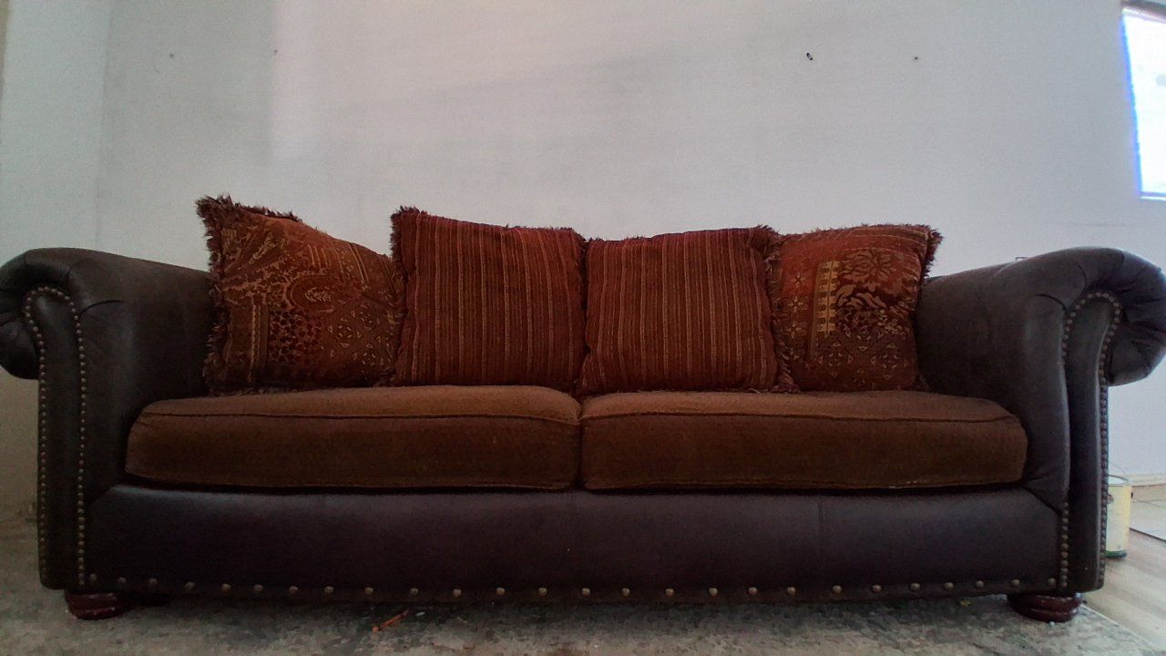 Brown leather and fabric sofa with decorative pillows