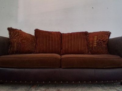 Brown leather and fabric sofa with decorative pillows