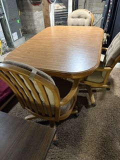 Dining Room Table and Three Padded Armed Rolling Chairs