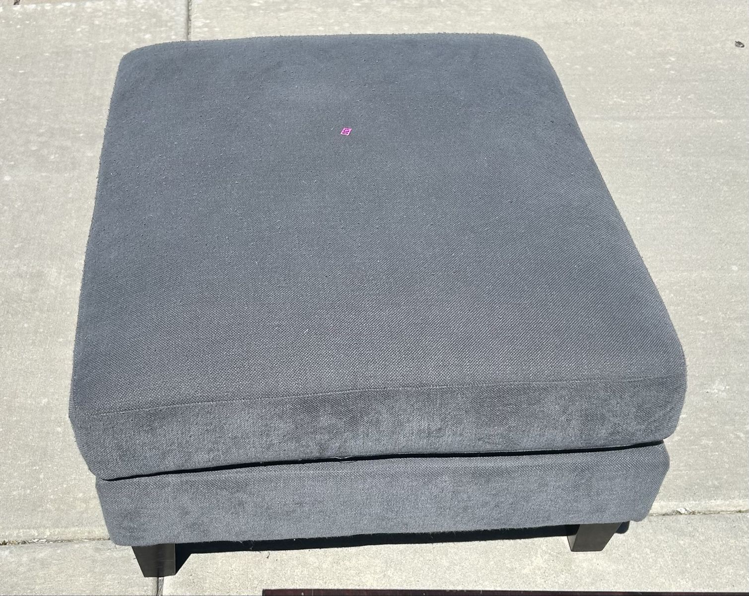 Gray Upholstered Ottoman with Dark Wood Legs
