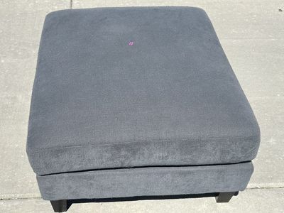 Gray Upholstered Ottoman with Dark Wood Legs