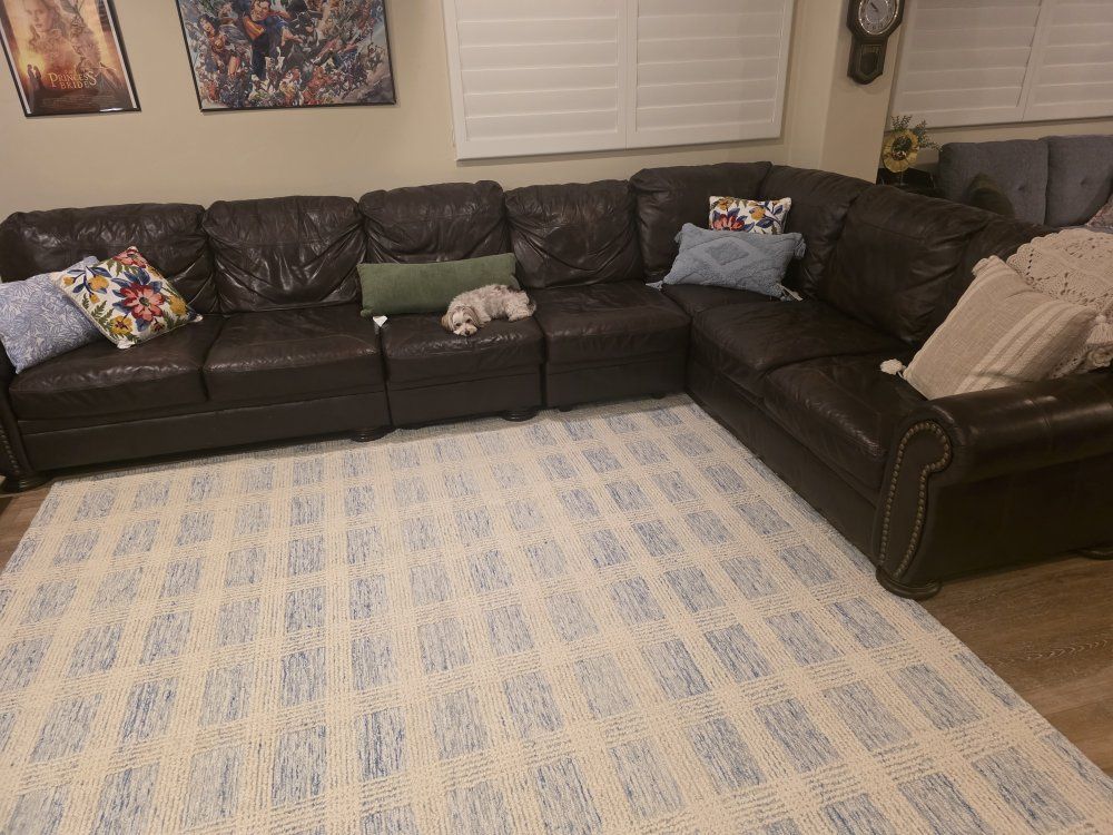 Brown leather sectional with matching chair.