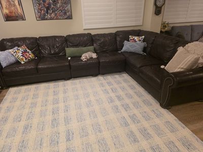 Brown leather sectional with matching chair.