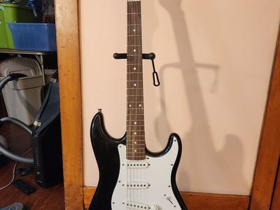 Full size Stratocaster electric guitar and two chords (one regular, the other an extension.) No brand name.