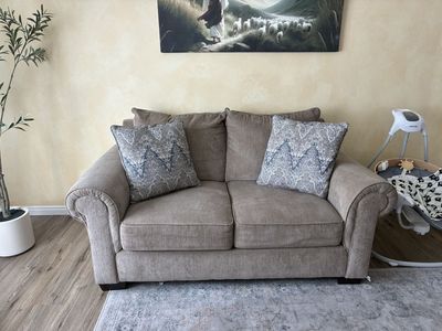 Taupe Fabric Loveseat with Rolled Arms.
