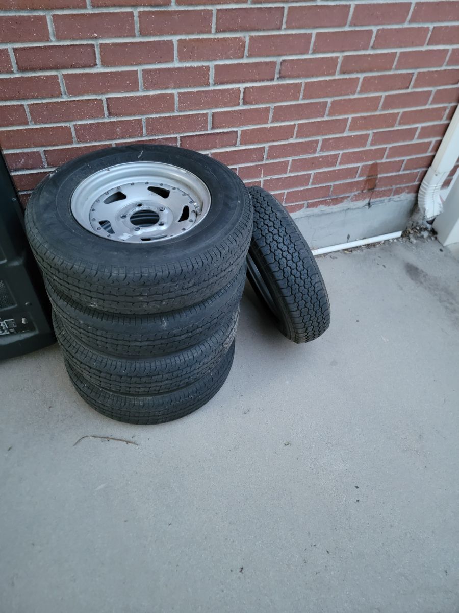 Set of 5 rims and tires for a trailer.