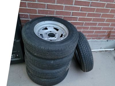 Set of 5 rims and tires for a trailer.