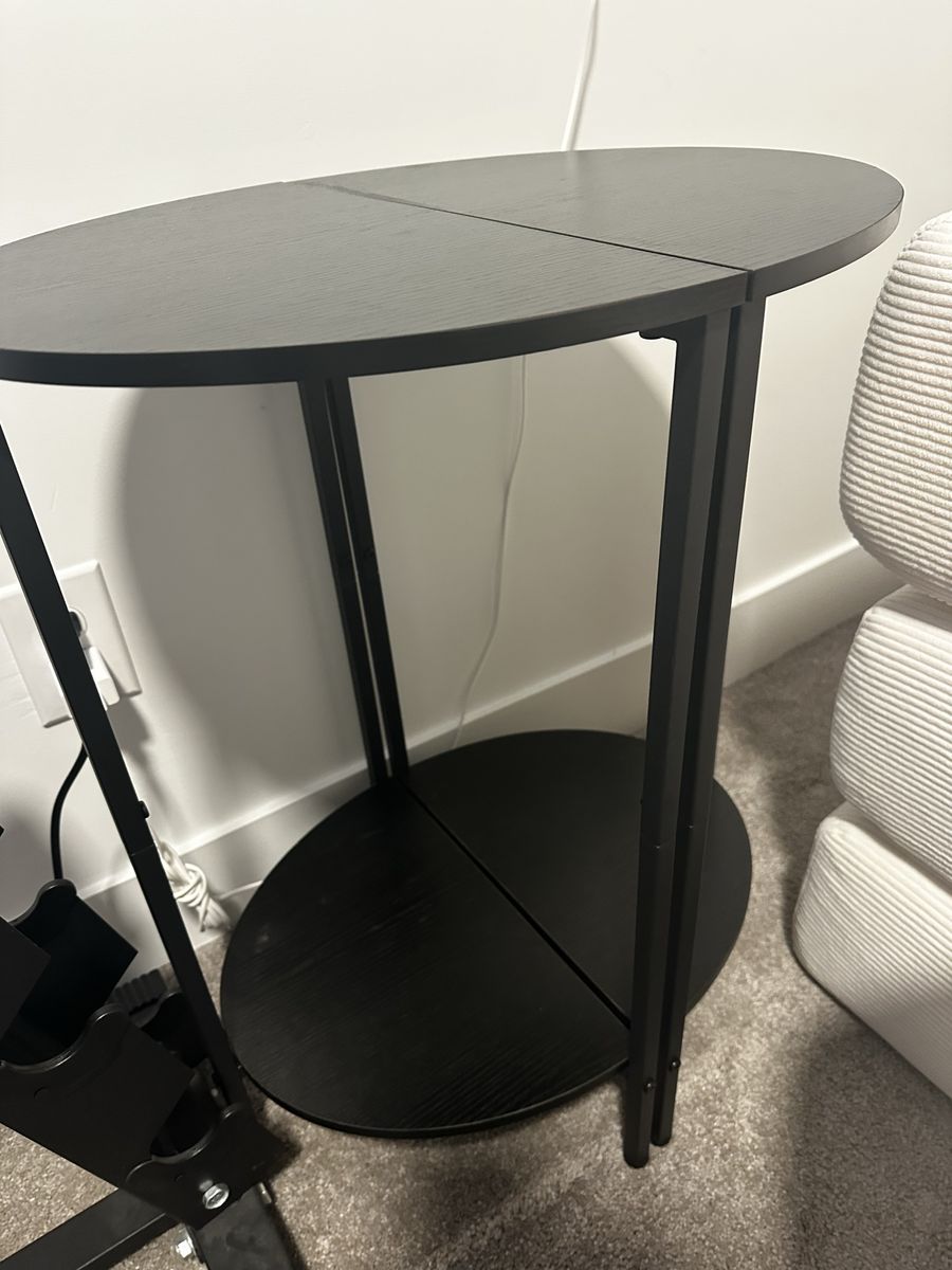 Black oval side table with bottom shelf