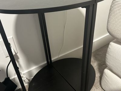Black oval side table with bottom shelf