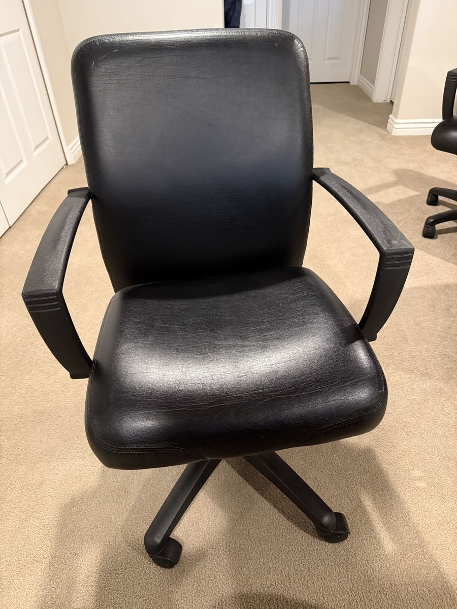 Four Black faux leather rolling desk chairs