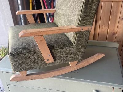 vintage Mid-Century Modern child's rocking chair features green textured vinyl upholstery and light