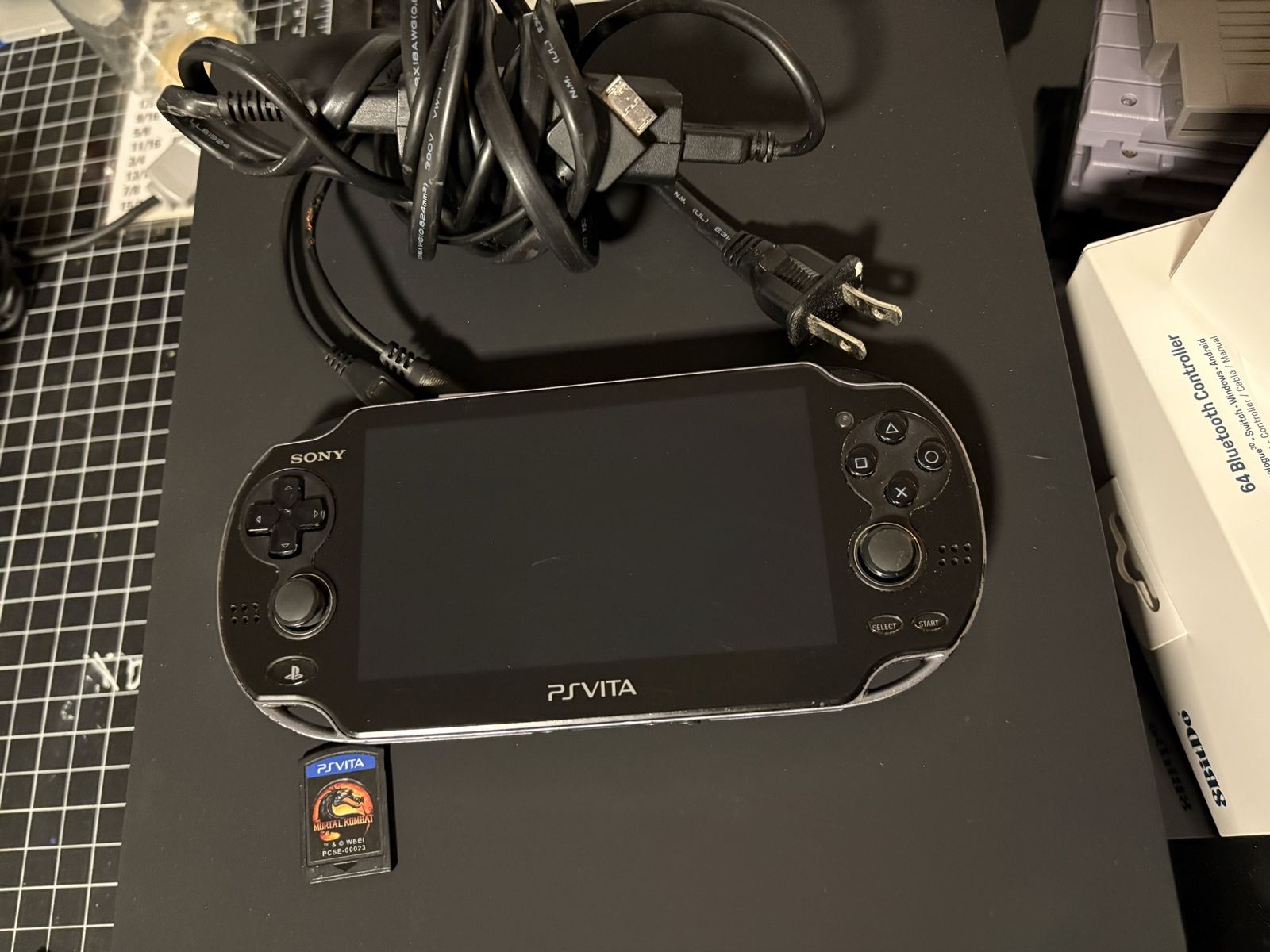 PlayStation Vita OLED model with charger and game PS