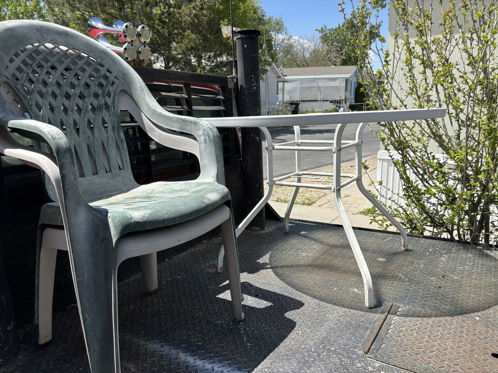 Glass picnic table with two plastic chairs