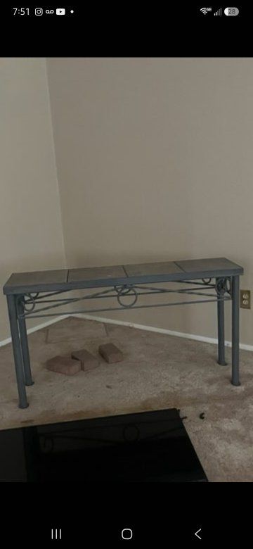 Iron table with stone tiles on top. Compliments the back of sofa or wall as  well.
