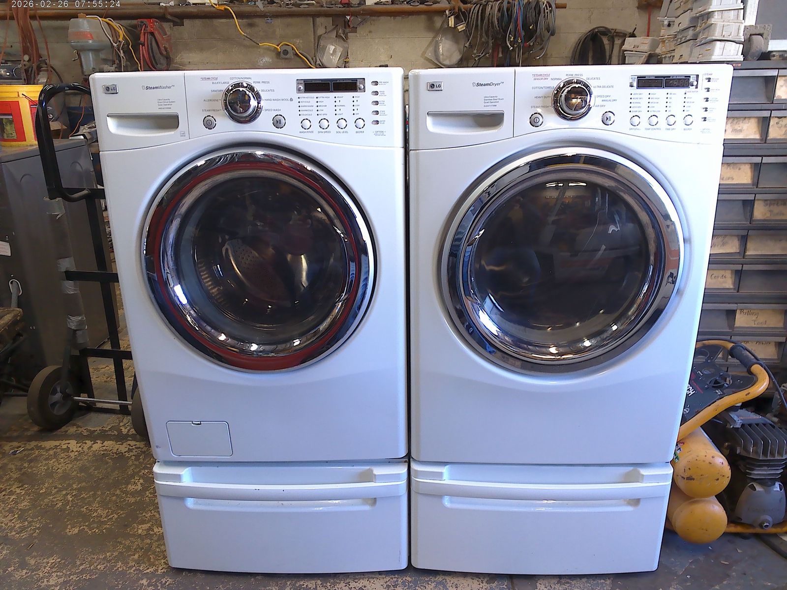 LG front load washer with matched electric dryer on pedestals