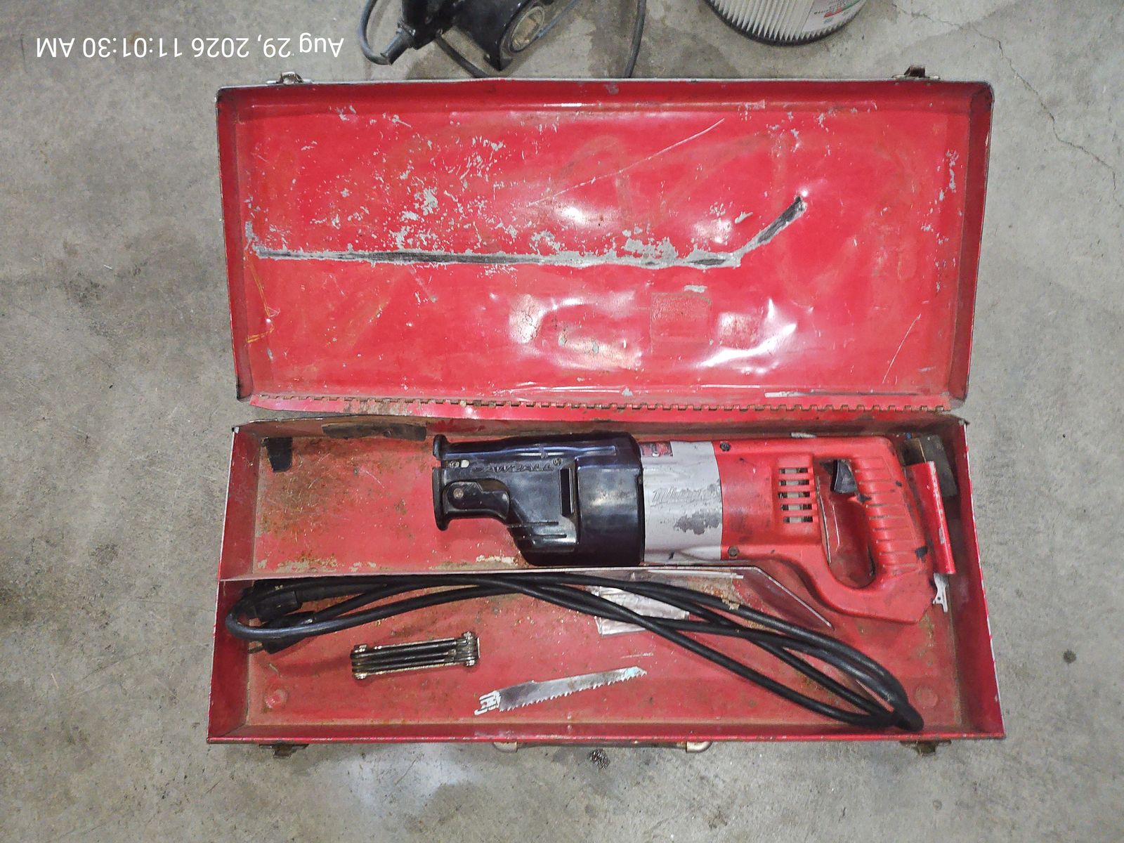 Vintage Milwaukee reciprocating saw, a.k.a Sawzall, with red metal carrying case