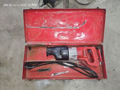 Vintage Milwaukee reciprocating saw, a.k.a Sawzall, with red metal carrying case