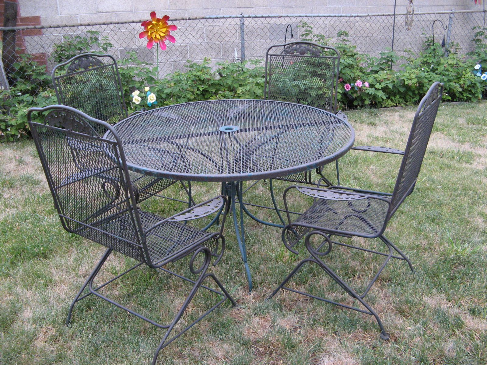 Vintage Russell Woodard wrought iron patio set, there's the 48" round table and 4 bounce/rocker coil spring arm chairs.