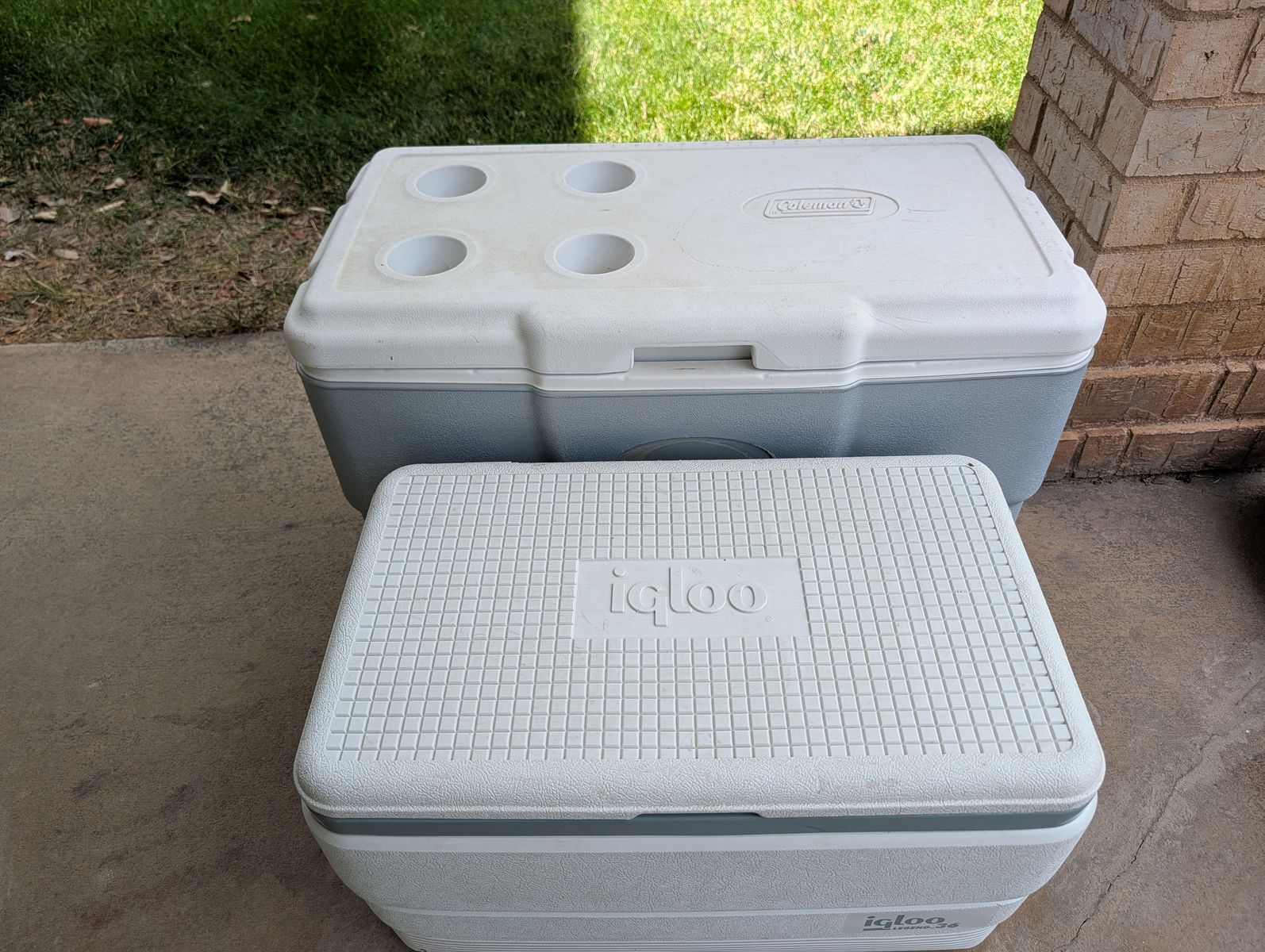 Two used hard side ice chests, lids fit tightly, handles secure