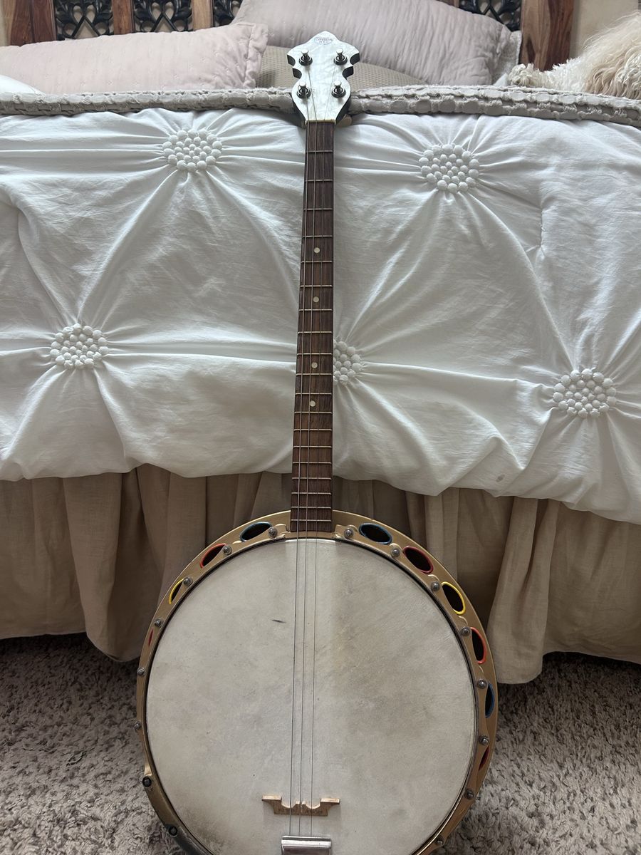 Vintage Gretsch  4 String Banjo with Resonator and Decorative Rim. Has a wooden neck with a dark fretboard and dots inlays