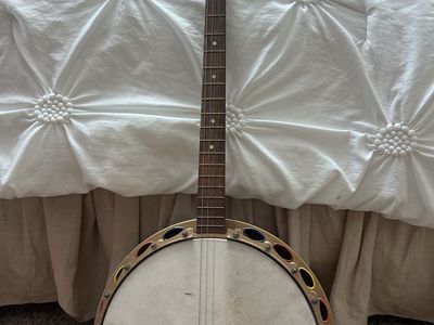 Vintage Gretsch 4 String Banjo with Resonator and Decorative Rim. Has a wooden neck with a dark fretboard and dots inlays