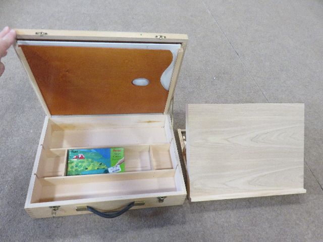 AN ARTISTS DELIGHT – A WOODEN MATERIALS BOX WITH PALATE AND WATERCOLOR PAINTS AND A COLLAPSABLE EASEL