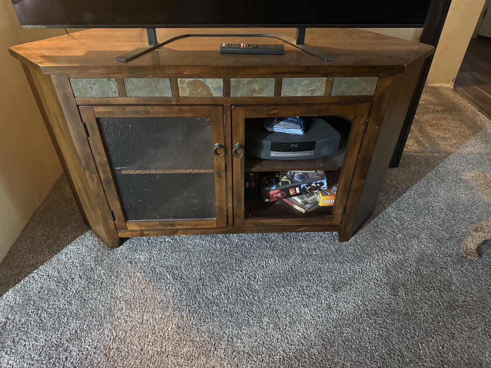 Wooden Corner TV Stand with Slate Tile Accents and Glass Doors