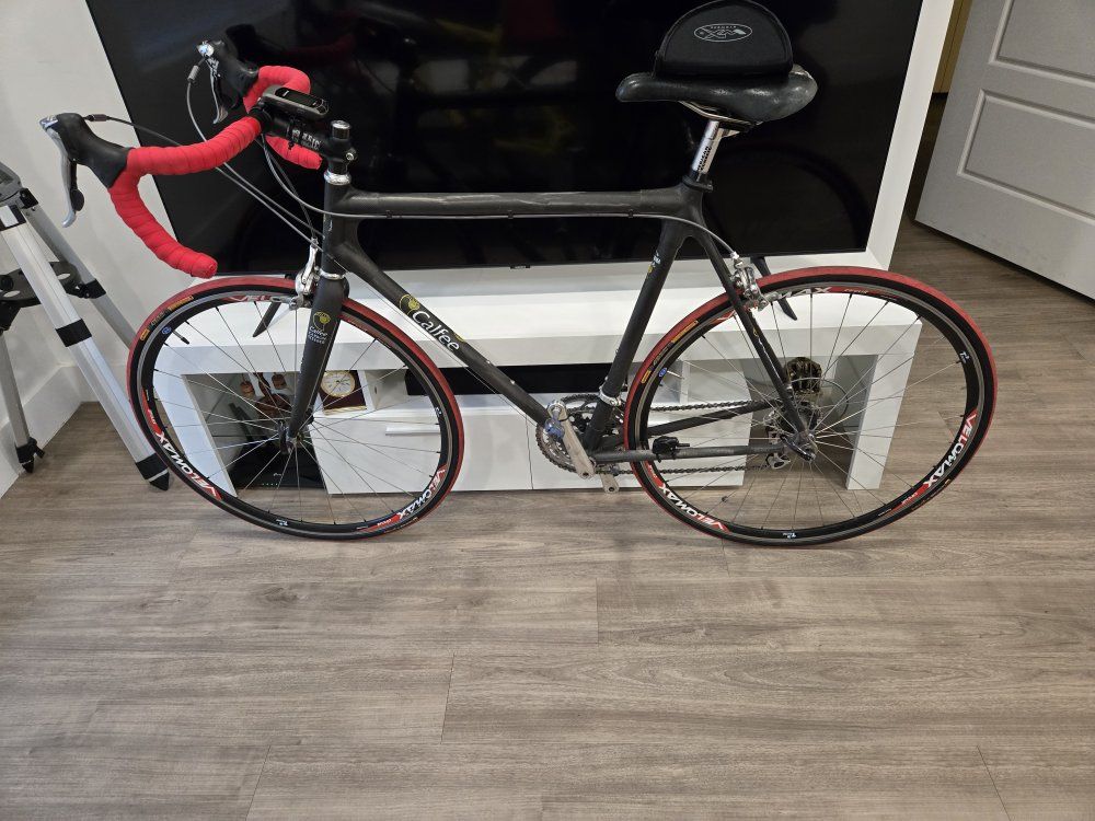 Calfee Luna Pro Carbon Fiber Road Bike - Velomax Wheels, Red Accent Trim. with three jerseys and a sunglasses