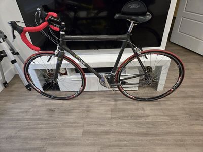 Calfee Luna Pro Carbon Fiber Road Bike - Velomax Wheels, Red Accent Trim. with three jerseys and a sunglasses
