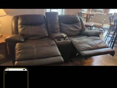 dark brown leather couch w/ reclining seats and middle storage/cupholders