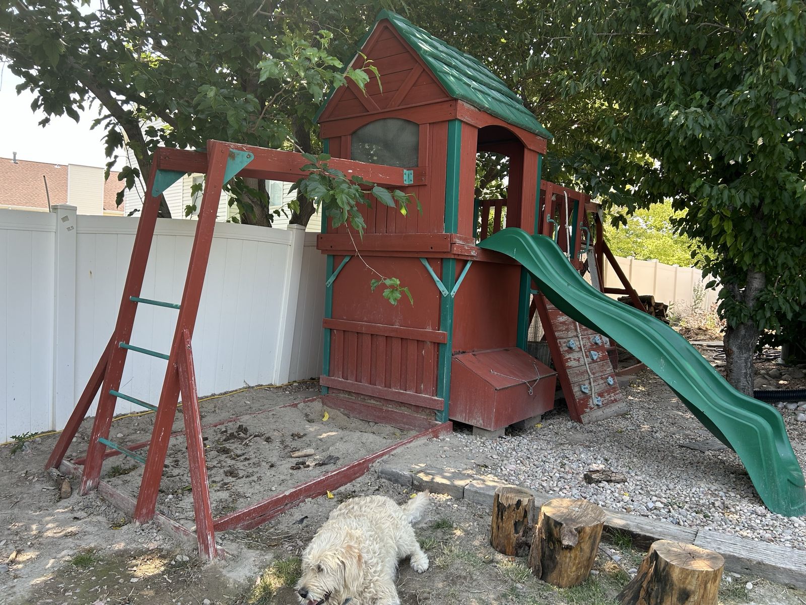 Playhouse with slide, monkey bars, climbing wall and space for swings.