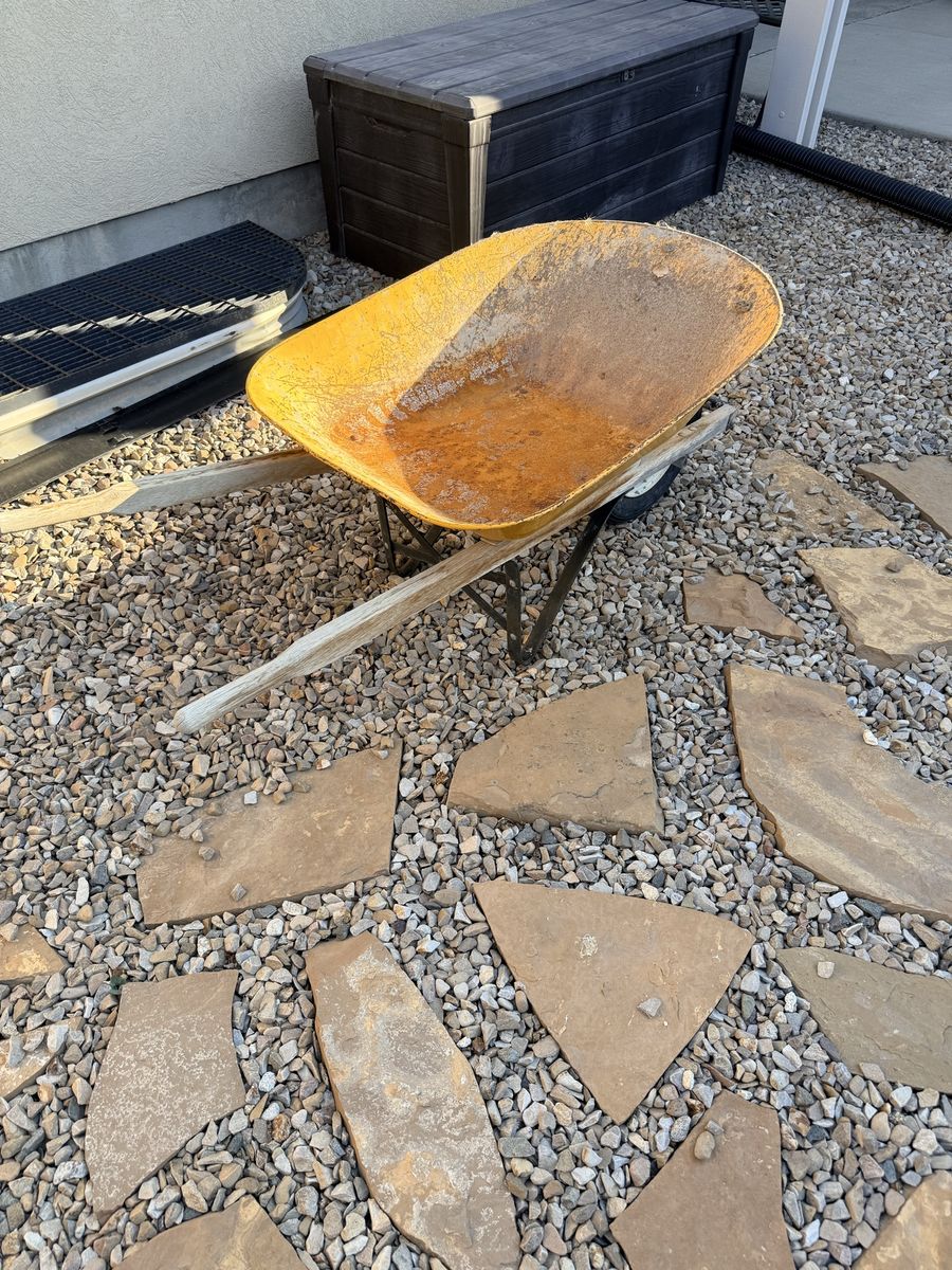 Vintage Yellow Heavy-Duty Wheelbarrow with Wooden Handles.