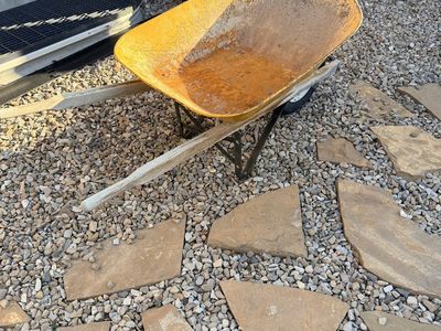 Vintage Yellow Heavy-Duty Wheelbarrow with Wooden Handles.
