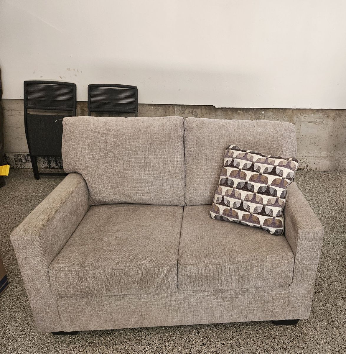 Cozy Brown Loveseat with Patterned Throw Pillow
