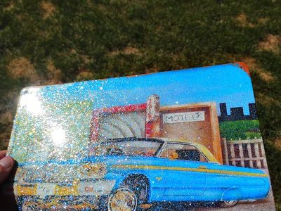 Custom painted gold and blue metal flake lowrider Impala tin signs.