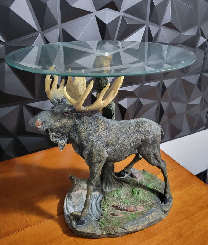 Oval glass coffee table with a Moose-shaped base.