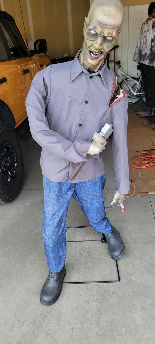 Life-Size Zombie Animatronic Halloween Prop 5'6 ft. Tall, Spooky Decor with Axe and Exposed Arm