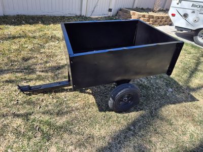 Yard trailer with dumping feature