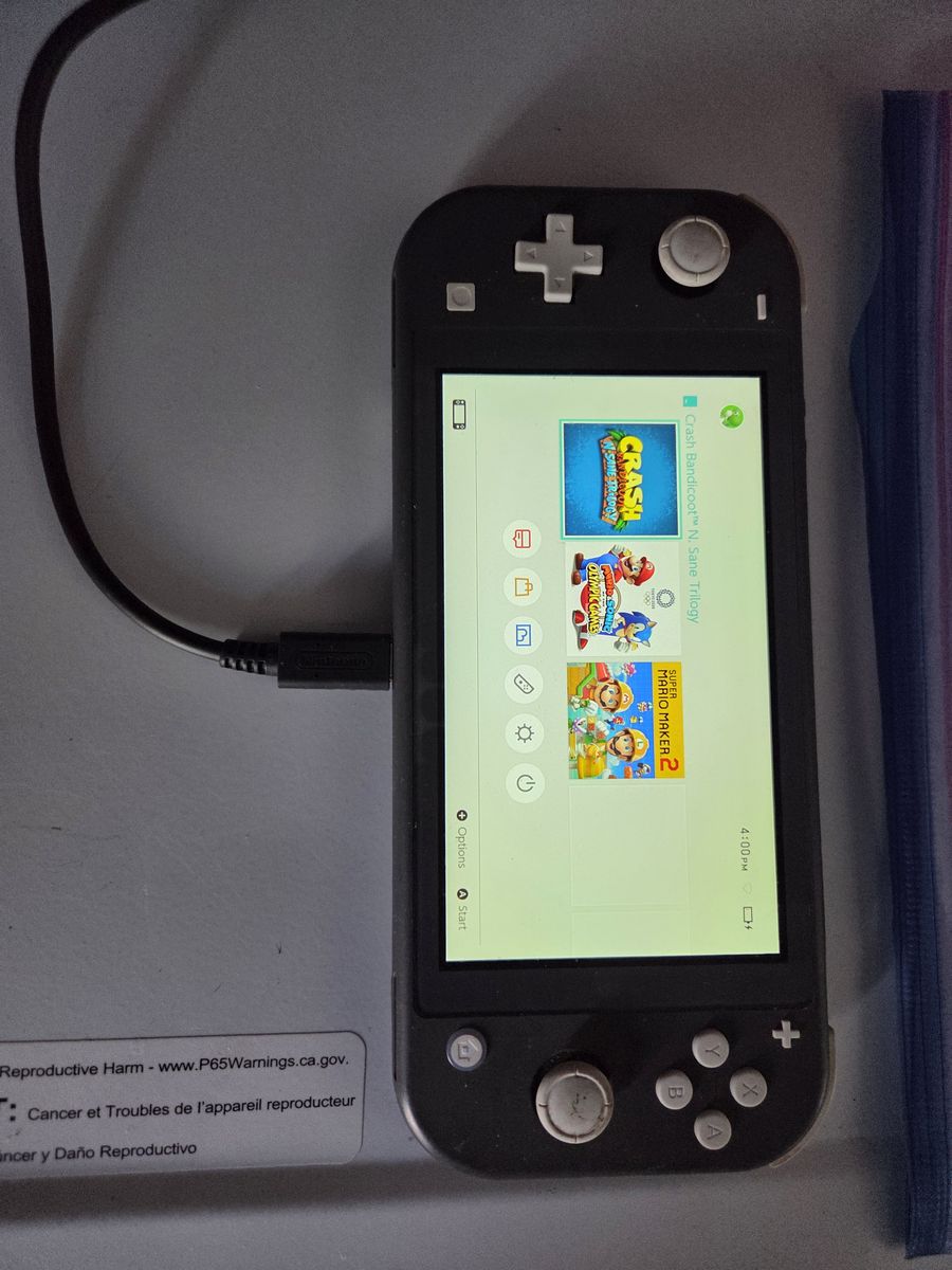 Grey nintendo switch with charger and Mario game 180