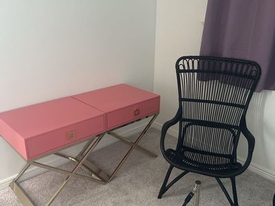 Pink and Gold X-Base nightstands and black rattan chair