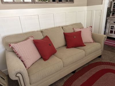Beige Fabric Sofa with Nailhead Trim and Decorative Pillows