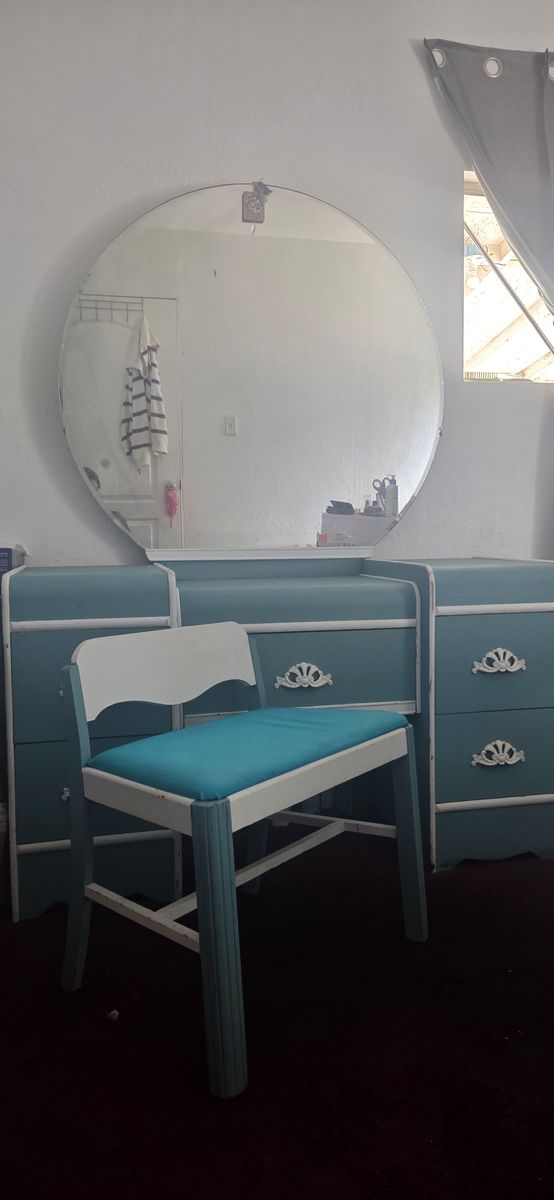 Antique vanity with mirror and chair and chest.