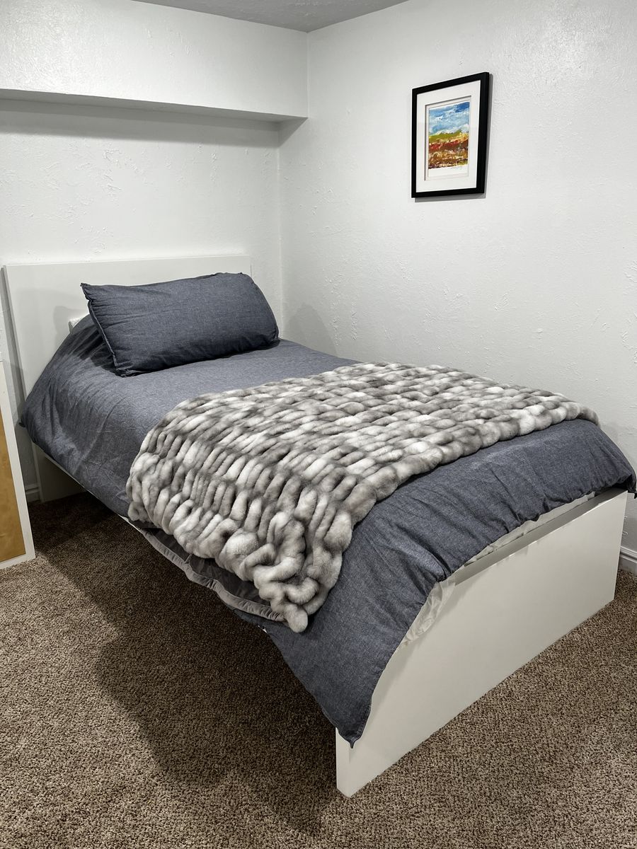 White Ikea twin bed frame, mattress, and bedding
