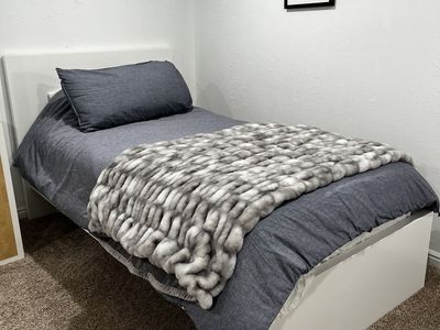White Ikea twin bed frame, mattress, and bedding