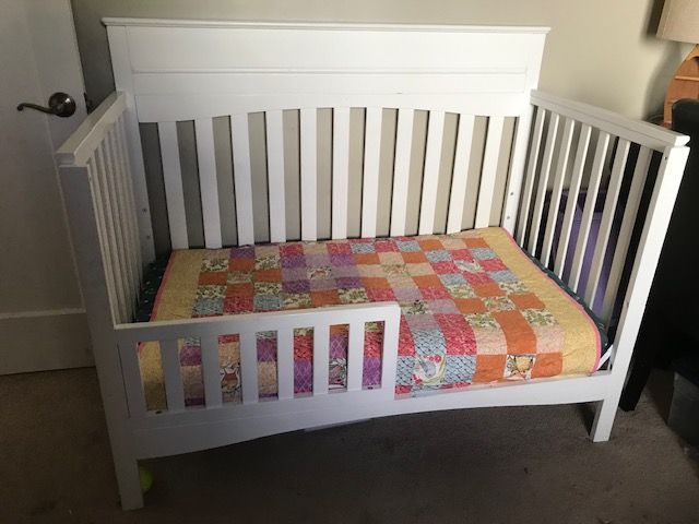 Baby crib which converts to toddler bed shown