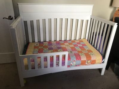 Baby crib which converts to toddler bed shown